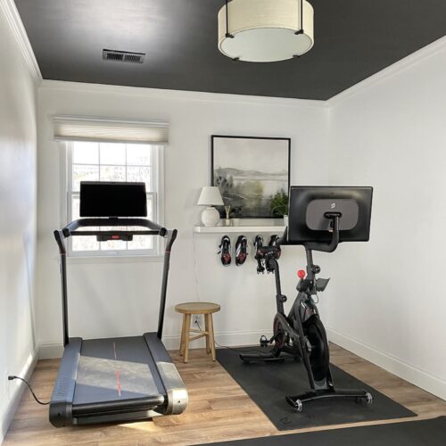 Modern Home Gym with Black Ceiling and White Walls, Peloton Tread and Bike